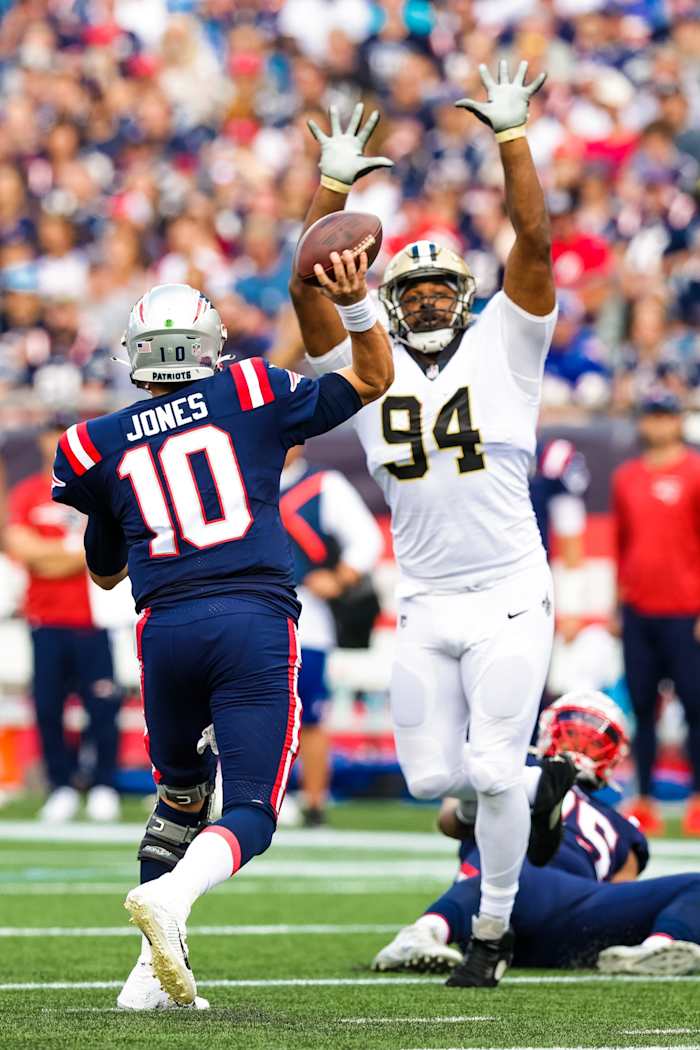 New England Patriots quarterback Mac Jones (10) passes with pressure from New Orleans Saints defensive end Cameron Jordan (94